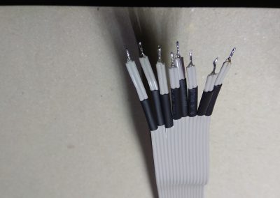 Detalle cable IDE con los hilos agrupados de 2 en 2 con los hilos trenzados cada 2 y con trozos de termoretráctil sueltos. Para conector KB2.