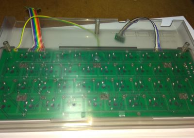 Vista inferior de la tapa con el teclado fijado y los cables pasados.