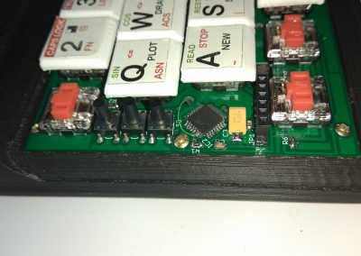 Atornillo el PCB del teclado a la caja. Y limpio los restos de plástico de las teclas rotas.