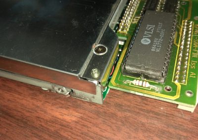 Retiramos el tornillo del centro de la imagen para ver el mecanismo de la disquetera.